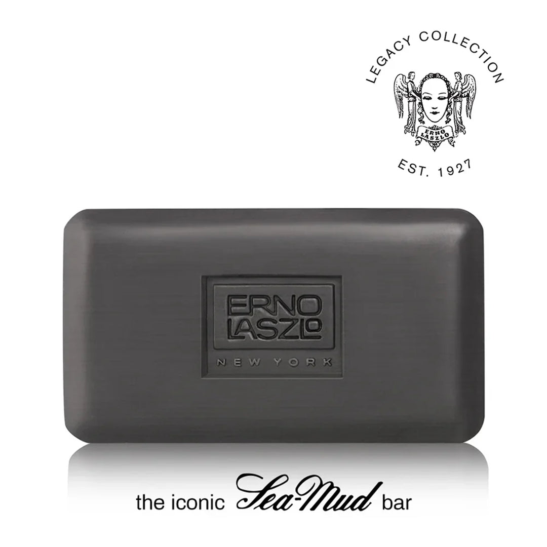 A dark gray rectangular bar of soap with a brushed metal finish, featuring an embossed logo that reads 'ERNO LASZO NEW YORK'. The image includes a 'Legacy Collection Est.