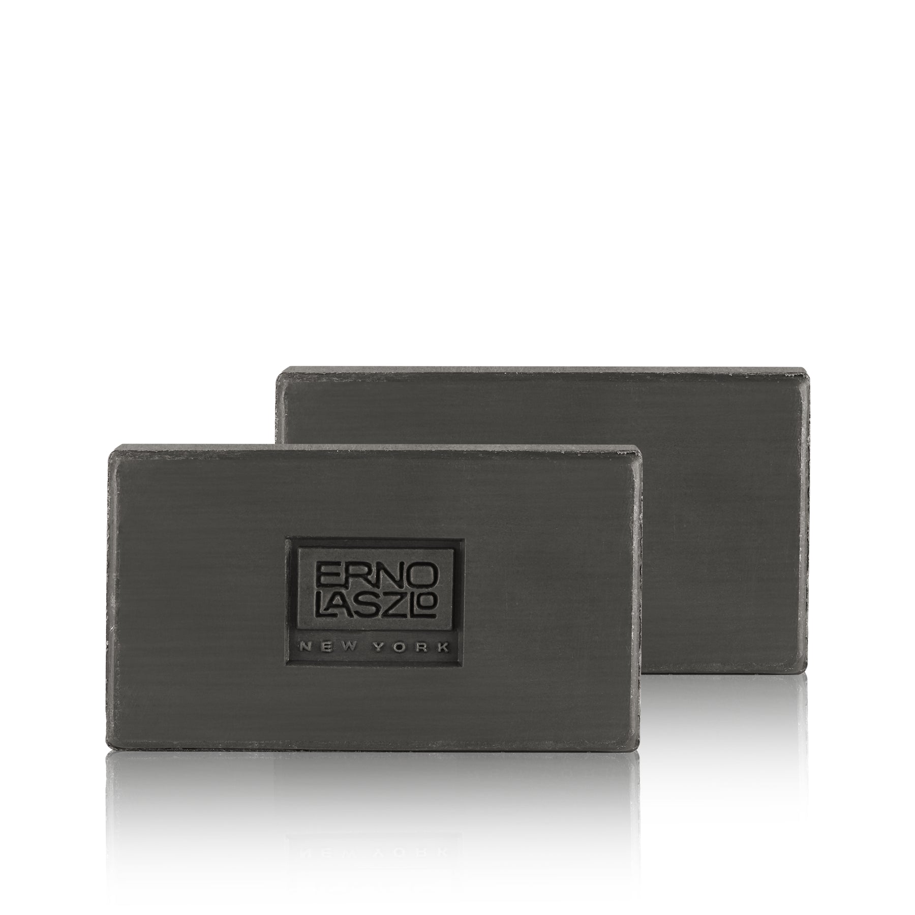 Two dark gray rectangular bars of soap stacked slightly offset, with the front bar embossed with the brand name 'ERNO LASZLO NEW YORK' on a clean white background.