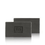 Two dark gray rectangular bars of soap stacked slightly offset, with the front bar embossed with the brand name 'ERNO LASZLO NEW YORK' on a clean white background.